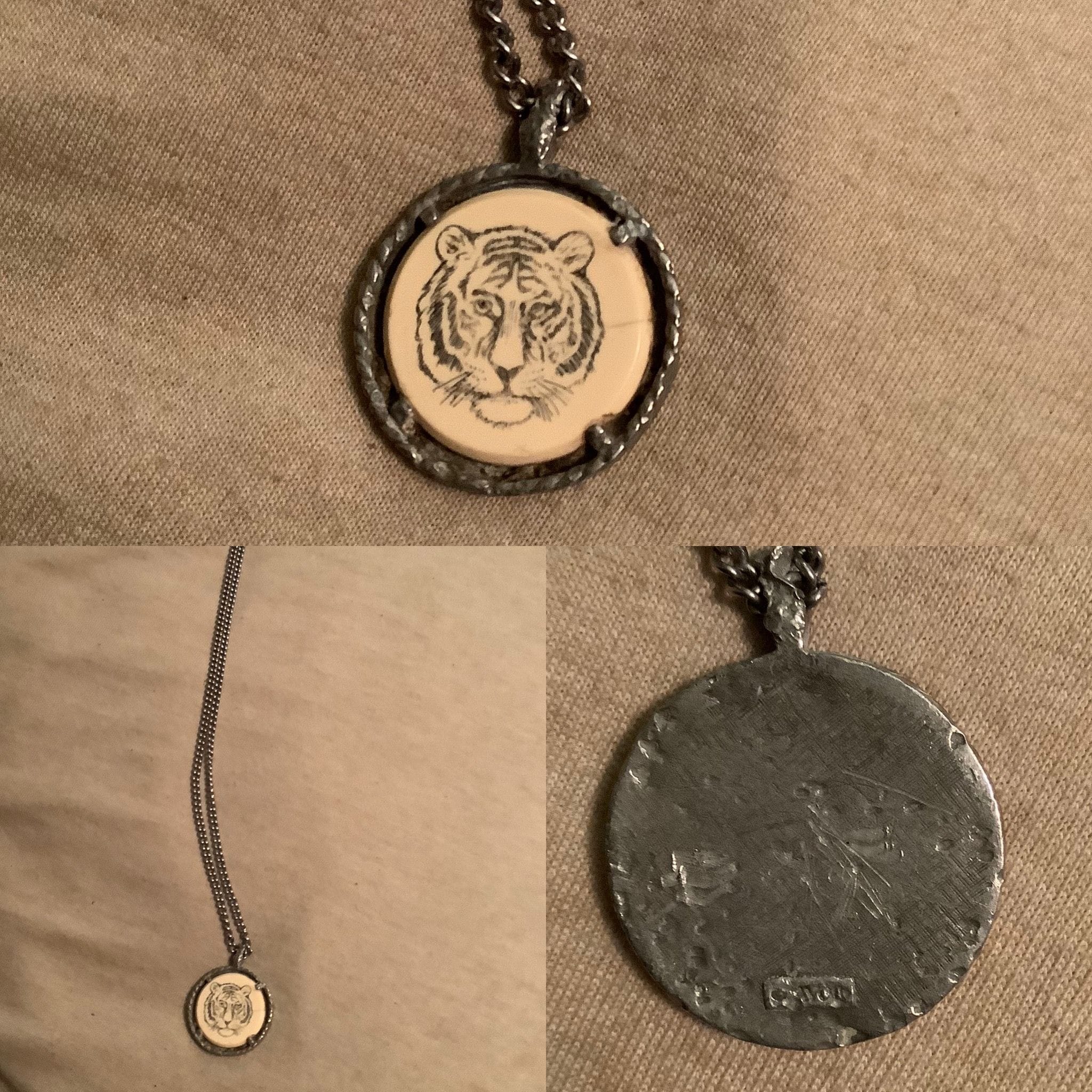 The Necklace A metal necklace with a tiger head printed on it.
